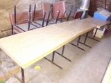 a long table with four chairs in a room