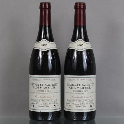 two bottles of wine sitting on top of a table next to each other