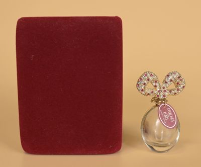 a small bottle of perfume next to a red box