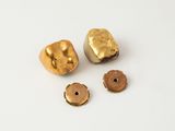 two gold nuggies and two small nuggies on a white surface