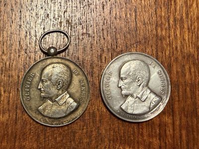 an old coin and a silver coin on a wooden table