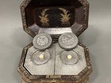 a silver box with two silver candles inside of it
