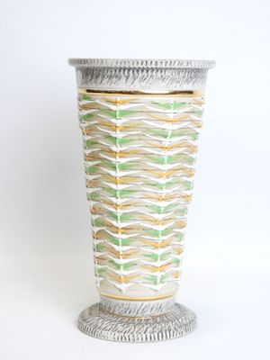 a white vase with a green and yellow design on it