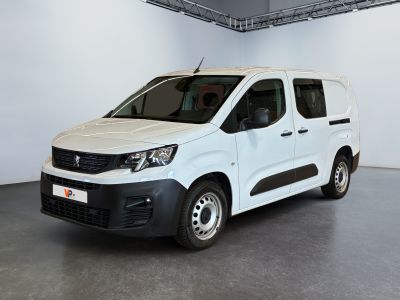 La camionnette blanche est garée dans la grande salle du bâtiment.