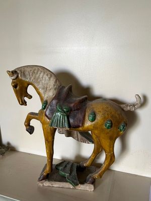 a statue of a horse on a shelf next to a mirror