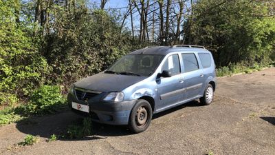 une camionnette bleue garée sur un parking près de quelques arbres