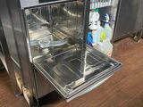 a stainless steel counter with a glass door and a dishwasher inside of it
