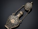 un collier ancien en argent et or, orné d'une bouteille en verre suspendue à une chaîne