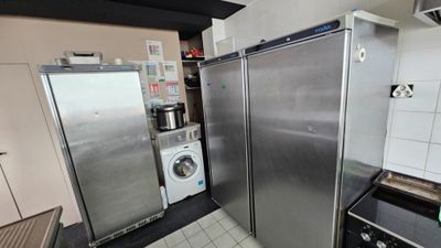 a refrigerator and a washer in a small kitchen