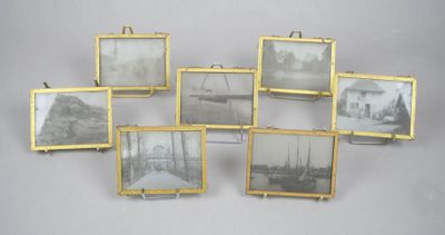 Six photos encadrées représentant des bateaux sont accrochées au mur.