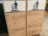 two wooden trash cans with signs on them on the floor