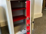 a small safe box with a red door in a room