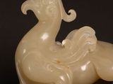 a white sculpture of a bird sitting on a table