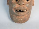 a clay mask with a smile on it ' s face