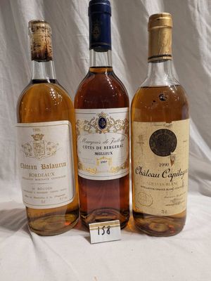 three bottles of wine are lined up on a white cloth