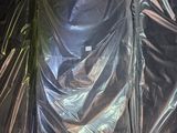 quatre matelas emballés dans du plastique dans un entrepôt