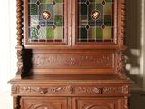 une armoire en bois avec une porte vitrée et un sol à carreaux noirs et blancs