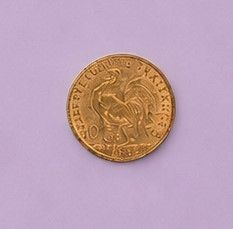 un gros plan d'une pièce d'or posée sur une surface violette