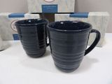 pair of blue mugs sitting on top of a table next to a box of boxes