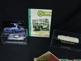 three different models of a bus and a car on display