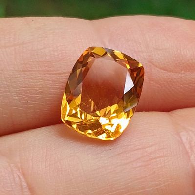 quelqu'un tient dans sa main un diamant jaune raffiné