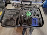 une valise contenant des outils, posée par terre