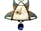 an image of a broochle with a horse and a blue stone