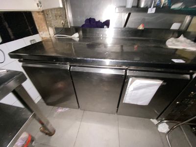a kitchen with a stainless steel counter top and black cabinets