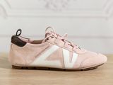 a close up of a pair of pink sneakers on a wooden table