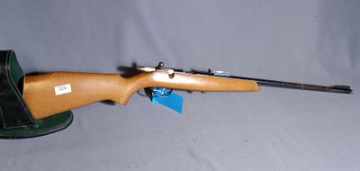 the rifle is laying on the table with a hat on it