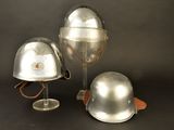 three helmets sitting on a table next to a wine glass