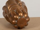 a bronze sculpture of a fist on a table
