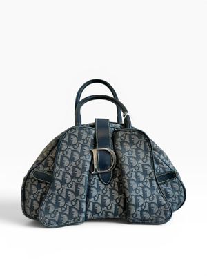 un sac à main bleu et noir posé sur une surface blanche
