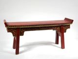 un banc rouge posé sur une surface blanche