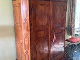 a large wooden armoire in the corner of a room