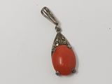 un pendentif en corail orange muni d'une bélière en argent