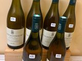 six bottles of wine sitting on top of a counter next to a wooden box