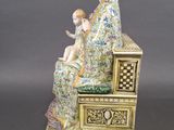 figurine of a woman sitting on a bench with a child