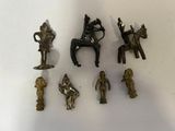 de nombreuses petites figurines en bronze posées sur une table