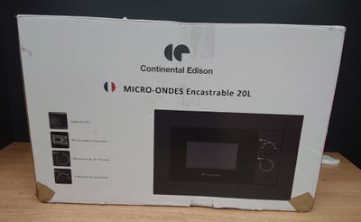 une boîte contenant un micro-ondes, posée sur une table