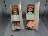 deux poupées qui se trouvent dans une boîte posée sur une table