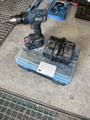 a cordless drill and two other tools on the floor
