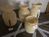 trois vases posés sur une table, sur lesquels sont apposées des étiquettes
