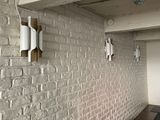 two lights on the wall above a sink in the kitchen