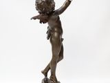 an antique bronze statue of a boy holding a bird on a white background