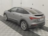 the rear end of a silver car parked in a garage