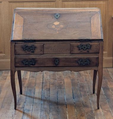 un bureau en bois avec un plateau en verre, posé sur un parquet en bois massif