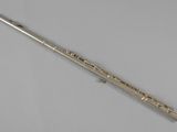 a silver flute on a white surface with a white background