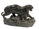 statue en bronze représentant un lion et un chien sur un rocher