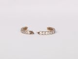 a pair of diamond hoop earrings on a white background